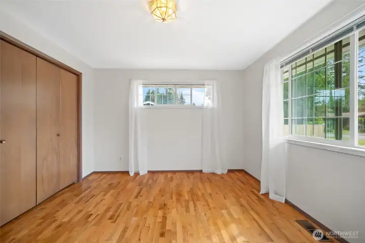 A comfortable second bedroom with hardwood floors.
