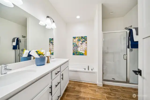 Find plenty of space to maneuver in the five piece primary suite bath with heated tile flooring.  The two sink vanity, with quartz countertops, spacious garden soaking tub, and wide step in shower offer style and comfort.