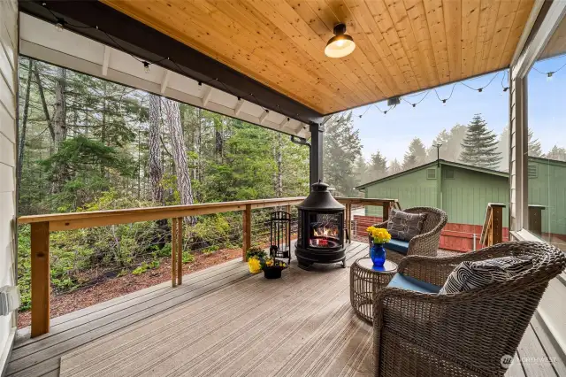 Appealing deck retreat with trex style decking, cedar ceiling, outdoor overhead lighting, and see-through wood and wire railings make a year round fresh air living space for BBQ or a favorite beverage.