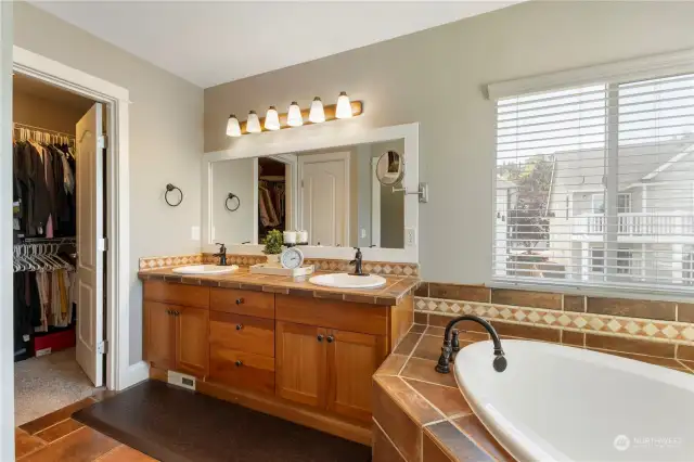 Primary bathroom has double sink vanity, soaking tub and separate shower.
