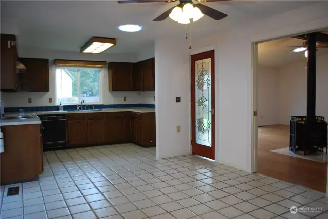 Tiled kitchen with sink and window overlooking the backyard.  View from dining area looking into the great room.