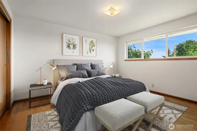Primary Bedroom with original hardwood floors. Trim & doors all original Mid-Century wood. Views out toward Mt. Rainier & Territory. Virtually staged to give you a sense of the space.