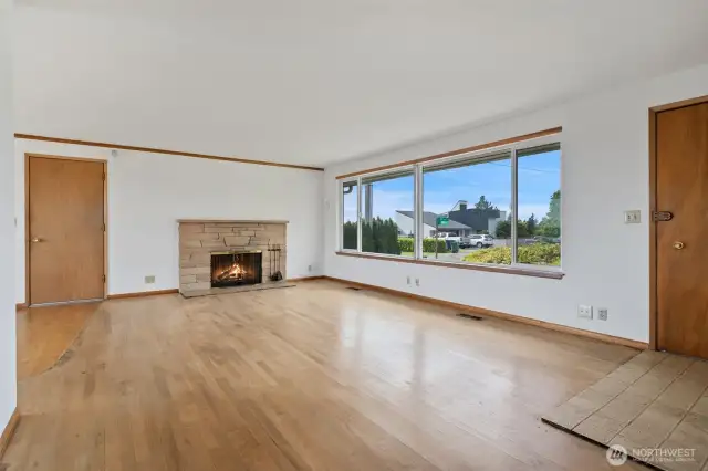 Living room with original hardwood floors, tile entry and large picture window. Shown here without the virtual staging.