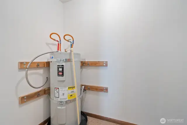 Hall utility room with storage and hot water tank.