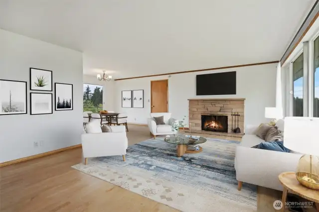 Living room with large picture windows, original hardwood floors & brick wood burning fireplace. Virtually staged to give you a sense of the space!