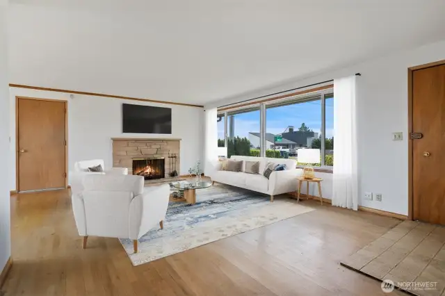 Living room with tile entry, large picture window, brick fireplace, hardwood floors and easy access to garage and backyard. Virtually staged to give you a sense of the spaces.