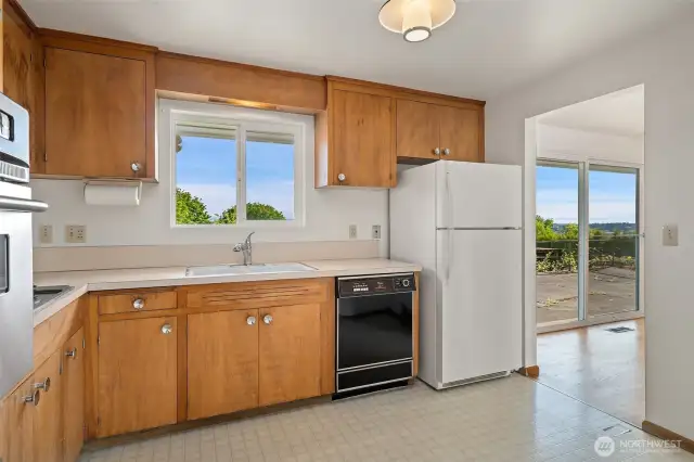 Original Mid-Century cabinets with eat in kitchen area and Mt. Rainier Views! Easy access to back patio through slider to the right.