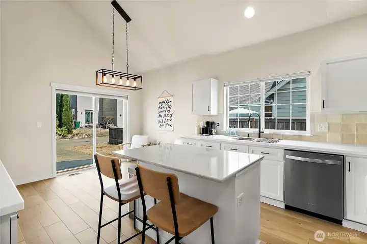 The kitchen is anchored by a versatile island designed for seating, prepping, and ample storage, blending style with convenience.