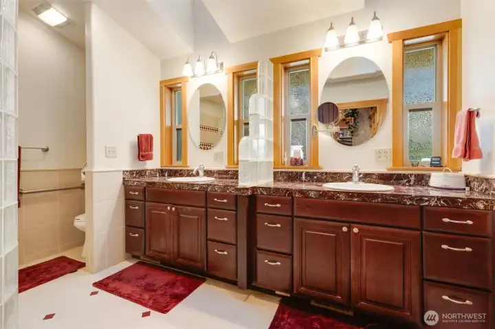 Primary bath featuring dual sinks, and walk in shower with rain head.