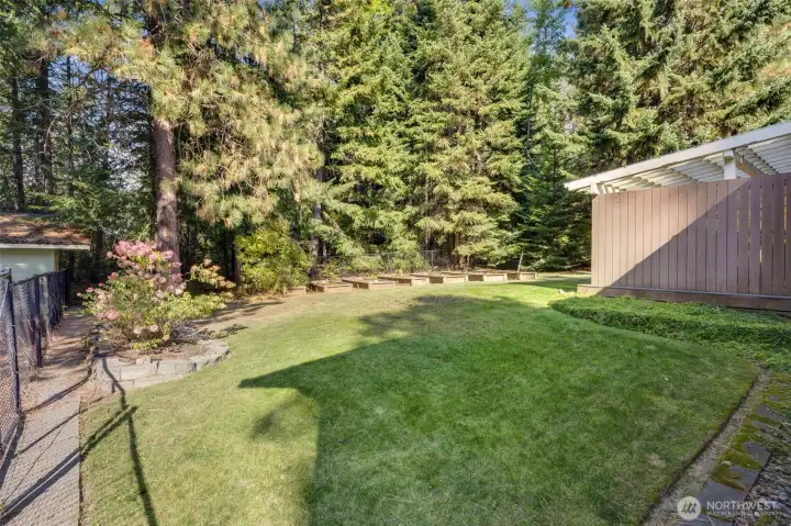 Completely fenced in portion on the property with raised garden beds, a covered deck area and direct access to the primary suite!