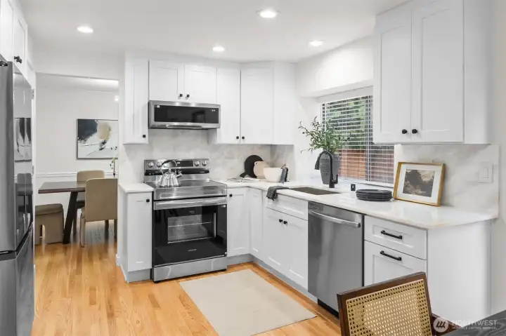 An absolute chef’s dream—sleek marble counters and backsplash, timeless white shaker cabinets, and all-new stainless steel appliances, fixtures, and lighting make this kitchen shine
