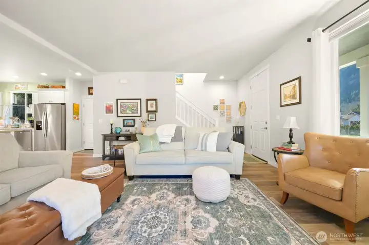 The living room looking back toward the front door and leading upstairs.