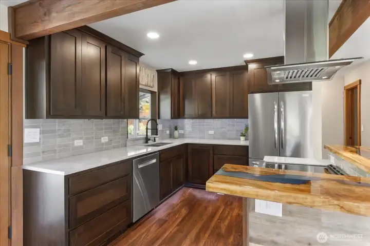 Stunning kitchen featuring a custom river table island bar top and a beautifully tiled backsplash. Stunning kitchen featuring a custom river table island bar top and a beautifully tiled backsplash.