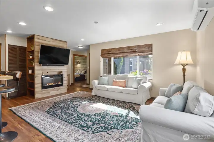 Living area featuring a fireplace and a dedicated TV wall, with transition leading into the primary suite. Living area featuring a fireplace and a dedicated TV wall, with transition leading into the primary suite.