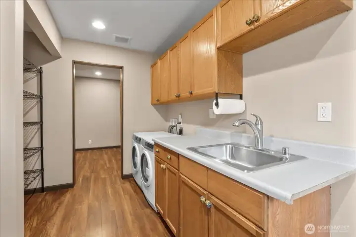 Roomy laundry area equipped with a sink, plenty of cabinets, and a separate pantry. Roomy laundry area equipped with a sink, plenty of cabinets, and a separate pantry.