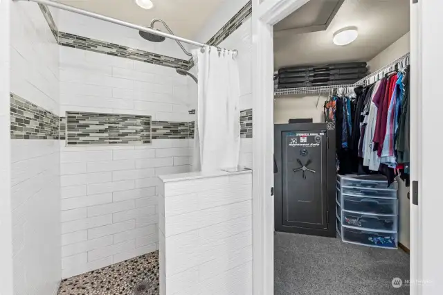 Floor to ceiling custom tile shower with rainfall showerhead & a spacious walk in closet