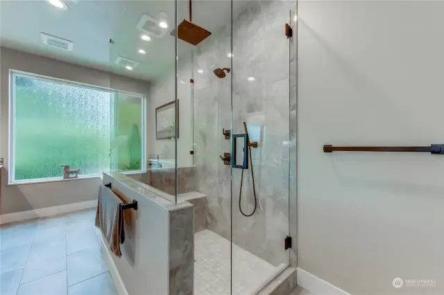 Heated tile floors and an extra-large walk-in Shower with a Bench. Rain Shower Head & frameless glass.