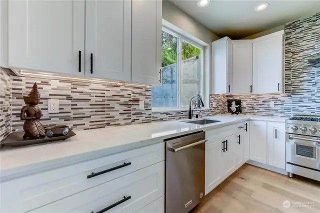 Sophisticated bright white custom cabinets with black hardware accents. Under cabinet dimmable lighting.