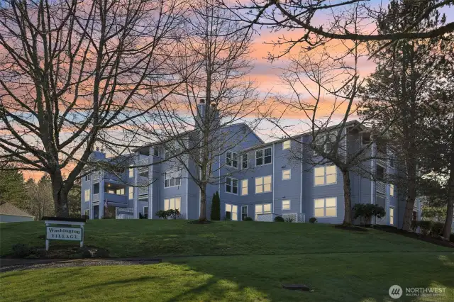 Located on a grassy hillside with lovely landscaping around building.
