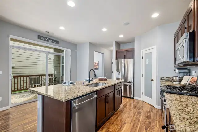 The covered outdoor deck becomes an extension of your living space, with the main floor office, powder room and garage access to the right, in the hall.