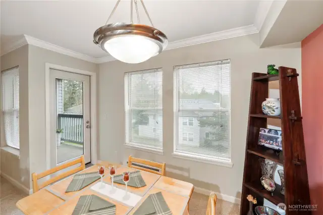 This dining space is bathed in natural light from oversized windows and a glass door leading to your private balcony—ideal for morning coffee or dining alfresco. The open layout offers relaxing views of the community green space while maintaining an intimate, welcoming vibe indoors.