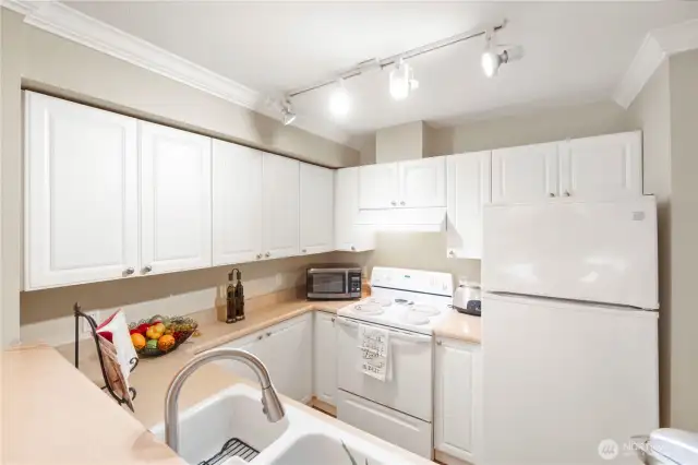 This clean, well-organized kitchen features crisp white cabinetry and sleek crown molding, offering a bright and timeless aesthetic. With abundant upper and lower cabinets, you’ll have plenty of storage space for all your culinary tools and pantry staples. The smooth-flow layout and wrap-around countertops make meal prep a breeze—whether you’re cooking solo or hosting friends.