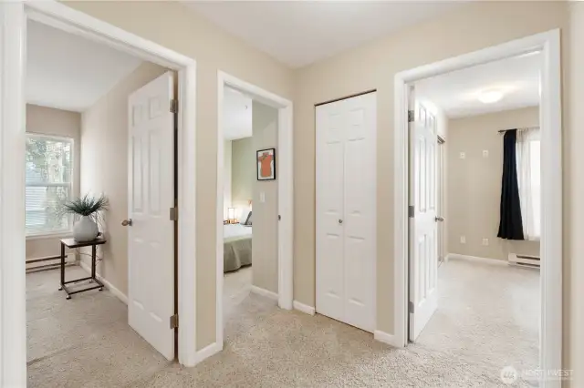 The upstairs hallway connects all three bedrooms in a smart, efficient layout that offers privacy and separation for each space. Neutral tones, plush carpeting, and natural light create a bright and welcoming transition between rooms—perfect for families, guests, or a home office setup.