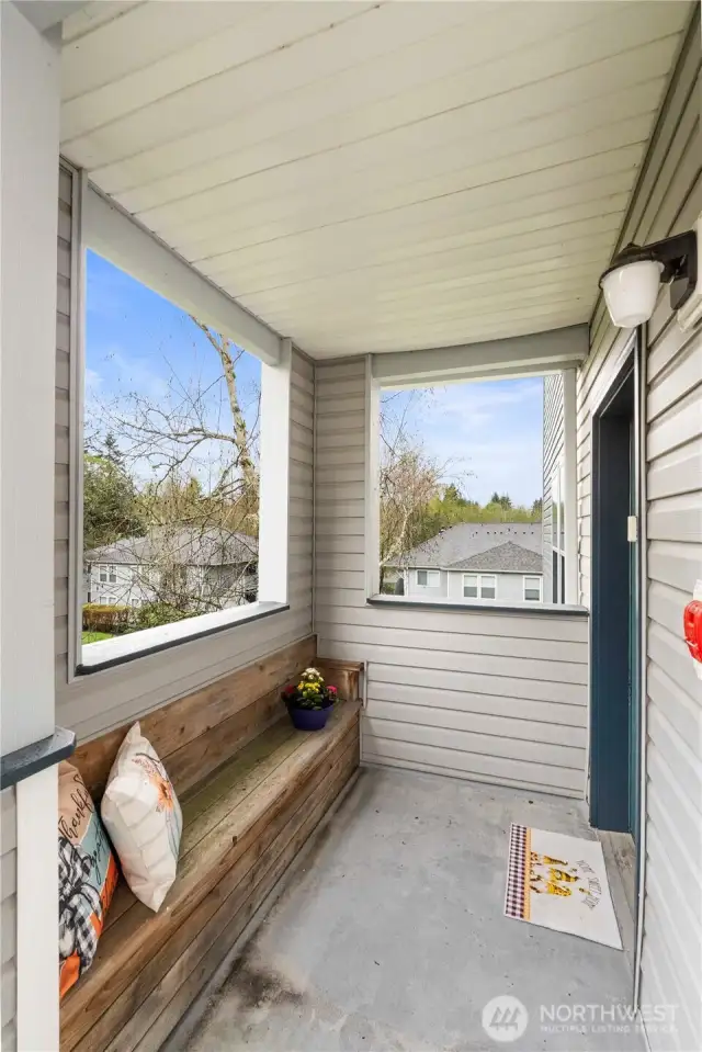 Welcome guests in style with this inviting covered front porch, featuring a custom built-in bench—perfect for enjoying a quiet moment outdoors or setting down groceries with ease. Thoughtfully designed for both comfort and practicality, this space adds personality and function to your private entry. Surrounded by trees and elevated views, it’s the perfect spot to take in the peaceful surroundings before stepping inside.