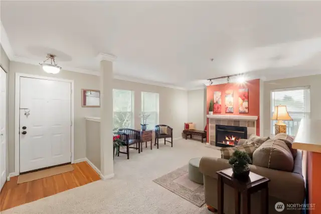 This wide-angle view shows off the thoughtful layout, with open sightlines connecting the living room, dining space, and kitchen. Subtle architectural touches like half-walls, crown molding, and column accents add character and definition while maintaining an airy, connected feel. Ideal for entertaining or everyday comfort.