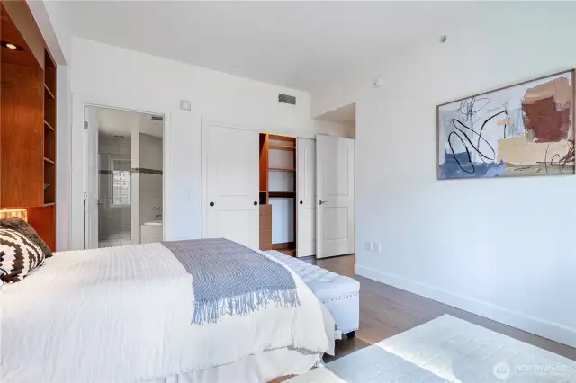 Master bed-Designed custom closet with ample hanging space, shelves, and drawers for organized and stylish storage.