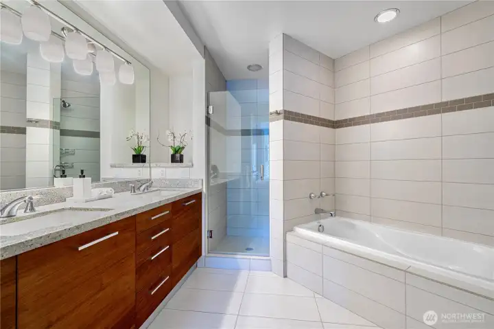 Master bathroom with glass-enclosed shower and deep soaking tub.