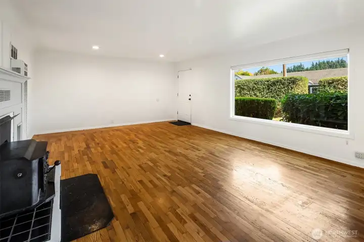 Bright living space with wood stove and large windows.