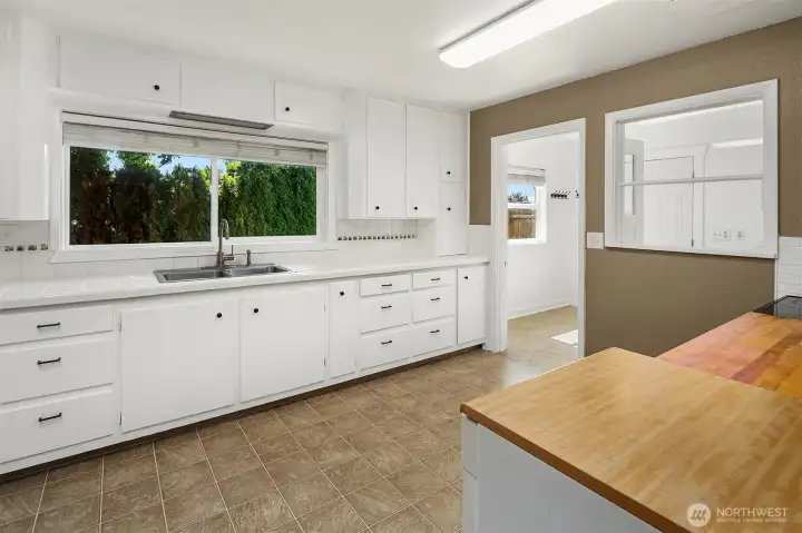 Kitchen flowing seamlessly into mudroom/laundry room.