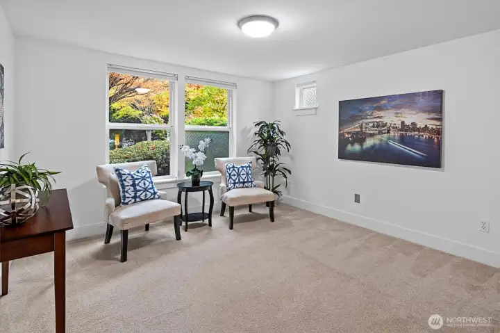 Flexible lower-level room ideal for home office, media room, or guest space with large windows for natural light. It has its own bathroom.