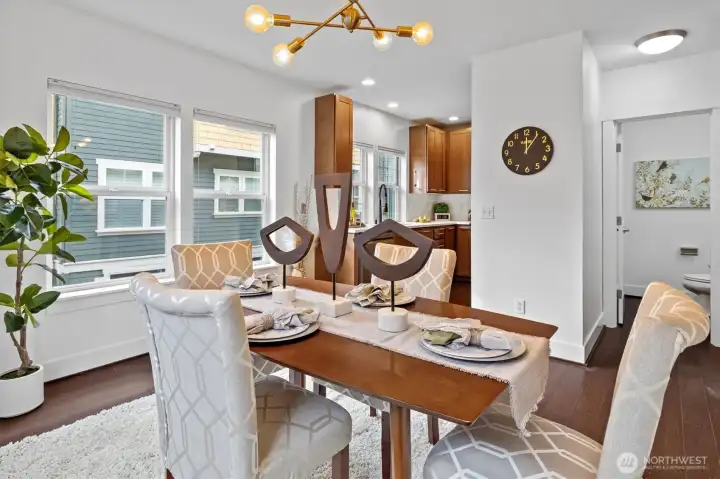 Open kitchen and dining area with large windows, updated countertops, and stainless appliances.