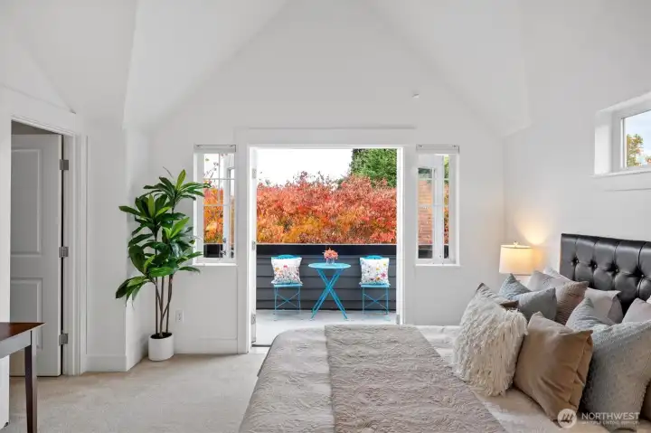 Primary suite opens to a private balcony surrounded by mature trees and fall color.