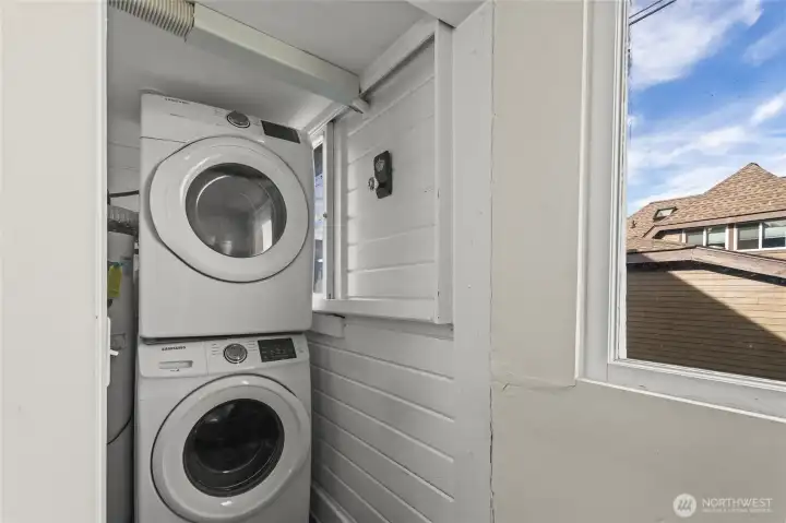 The stacked washer and dryer set and water heater are tucked away in this laundry room on the north side of the house just off the dining room. There's space for some storage shelves too.