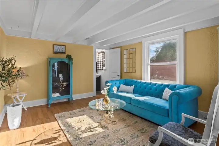 This front sitting room is the room guests enter from the covered front porch. Sunlight spills in from north and west windows. Take off your coat and shoes and shake off the day.