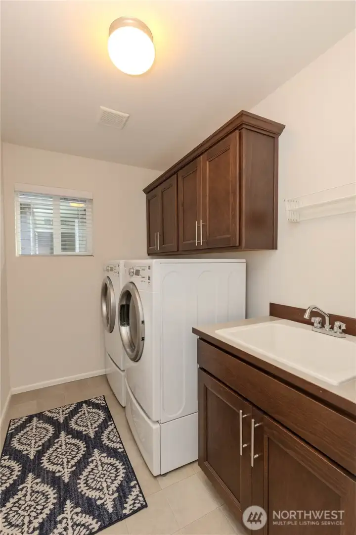Large laundry area, with storage and sink.