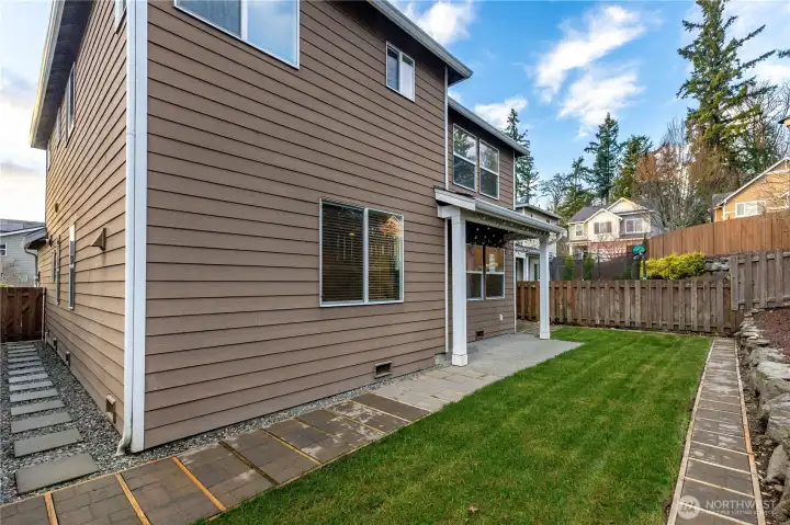 Well kept yard and home, with cement steps and pavers.