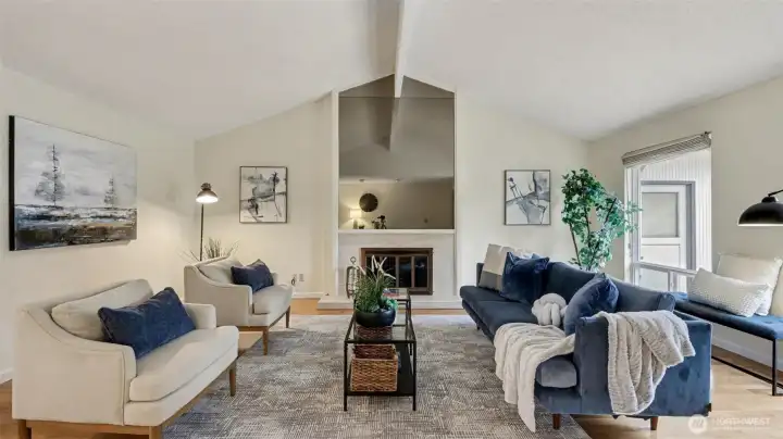 Vaulted ceilings and a central fireplace make this living room the perfect place to unwind or host guests.