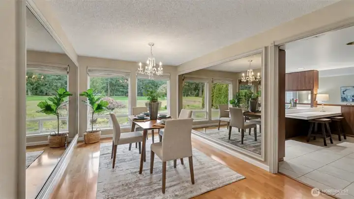 Dine surrounded by natural light in this beautiful dining space framed by expansive windows and peaceful outdoor views.