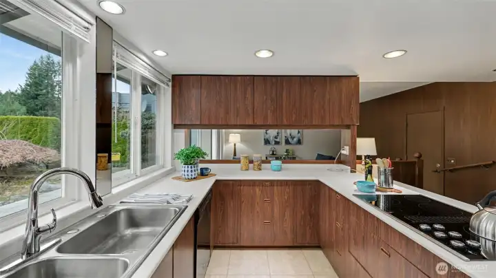 The kitchen offers plenty of prep space and cabinetry, with natural light streaming in through oversized windows.