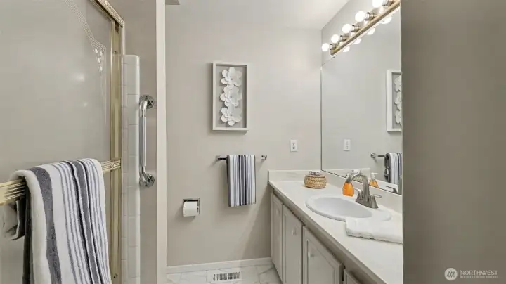 This secondary bathroom offers a generous vanity with plenty of counter space and a practical tub and shower combination.