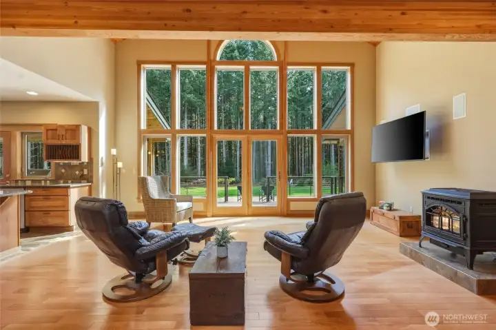 Nature integrates with architecture in this wall of windows set beneath a tongue-and-groove cedar ceiling and exposed beams.