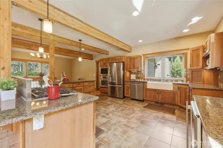 Dreamy kitchen fitted with stainless appliances and charming farm sink; 5-gas-burner Wolf stove with downdraft system and wall oven make cooking a delight.