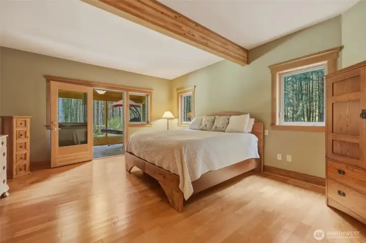 Primary bedroom with beam, several windows, and enticing solarium!