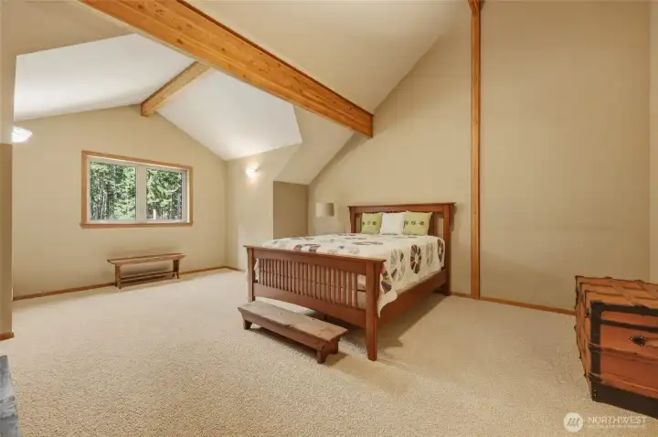 Expansive 2nd en suite bedroom exudes character with the vaulting, wood beams and dormer architecture. This room also features a walk-in-closet with pocket door.