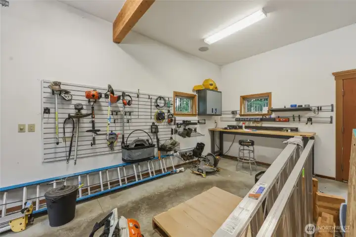 This 4-car garage is out of this world!  Finished walls, exposed beams, spacious with tall ceilings and great lighting, as well as multiple windows and an exterior door for ease. Gladiator wall rack system and cabinet are included.