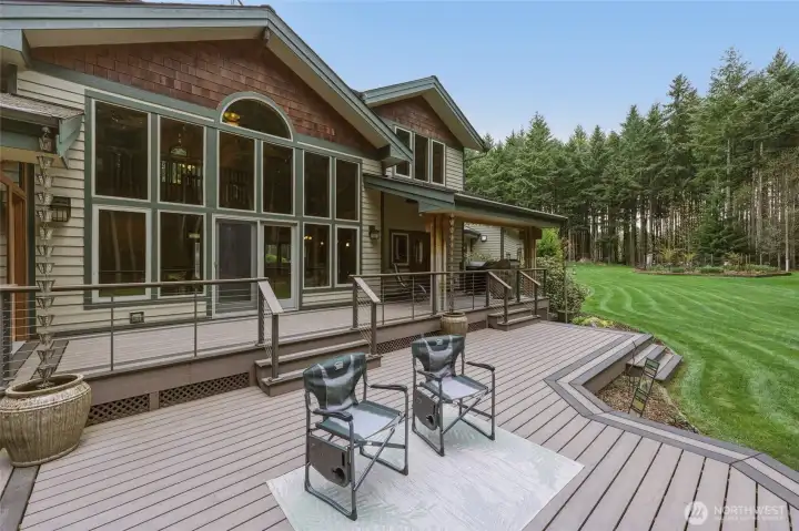 Composite decking, accessible from three points in the home, brings further quality with its multi-level design, cable railings, handsome border, and attractive shaping.